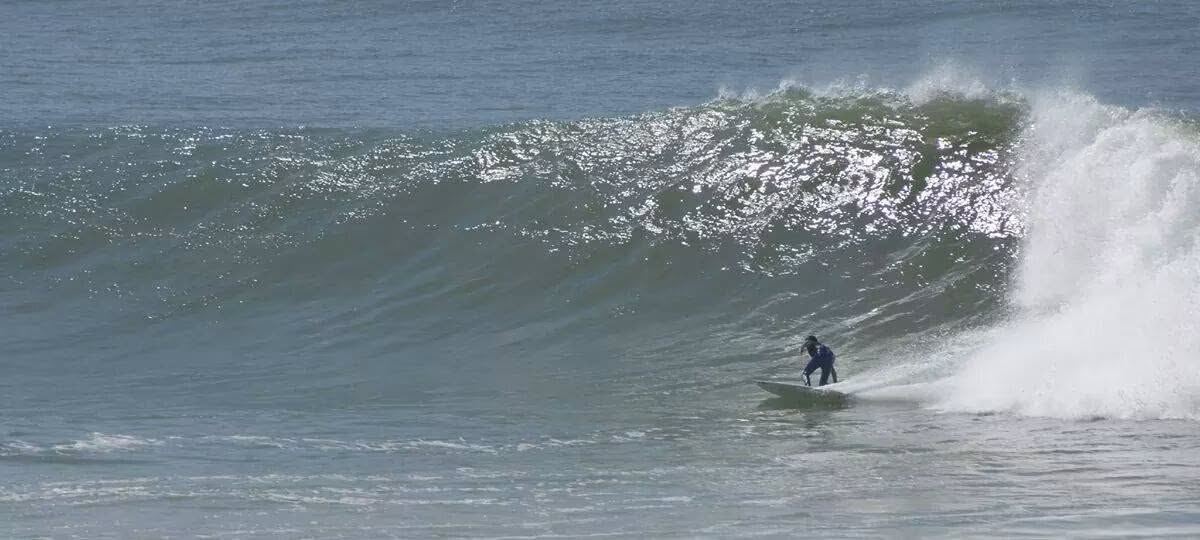 Kevin racing along a long, peeling wall of water