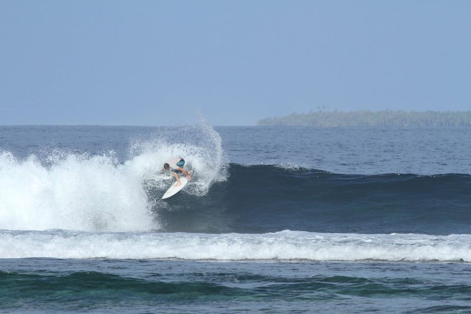 Kevin snapping off the top of a wave in a burst of spray